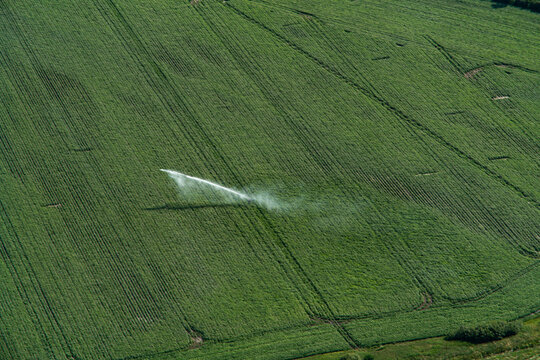 Sky View Of A Grass Field With A Water Canon Working