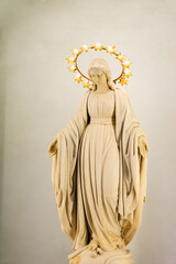 female statue with a halo over her head in a catholic church