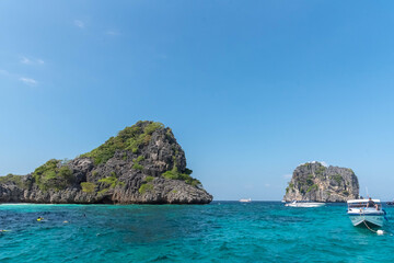 Fototapeta premium Vintage and retro toning of tropical beach with blue sky and clear sea which including of a wooden umbrella and chair in sunrise time with vintage retro tone. Vacation time as concept. 