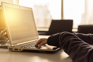 Side view of a working woman is typing on laptop computer with blank copy space screen for texting a message. Working time as concept.	
