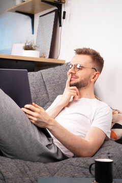 Young caucasian programmer man sit on sofa video calling remote friend woman talking in online webcam chat on laptop at home office. Distance dating videocall concept.