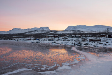Frozen lake with mountain backdrop in Abisko, Sweden
