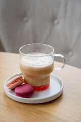 A cup of coffee with iice cream, syrup and macaroons on the table. High quality photo
