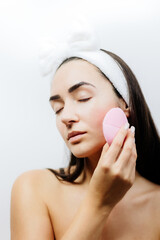 happy woman using electric cleansing brush for face deep cleaning. Beautiful naked woman clean face...