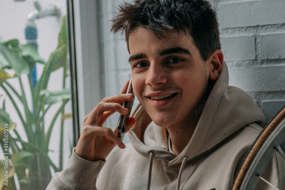 Wall mural young man with mobile phone at home