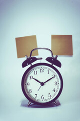 Naklejka premium Vintage retro alarm clock and stack of coins to represent It's time to do money saving for retirement planning as concept.