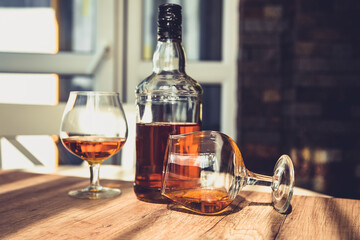 bottle of brandy and two glasses of alcohol in a bar