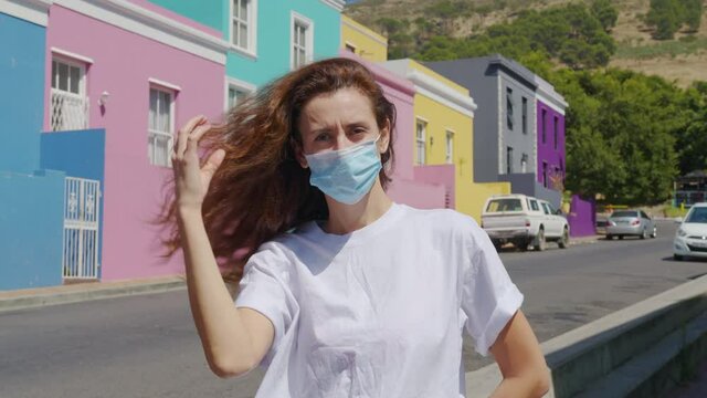 Woman masked during quarantine in the streets of colorful buildings neighbourhood Bo-Kaap Cape Town South Africa.