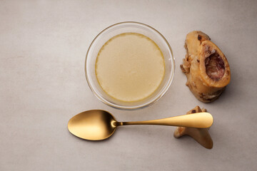 Bone broth in glass bowl. Top view, copy space. Beef bones are source of natural collagen, which is useful for joints and provides body with essential amino acids