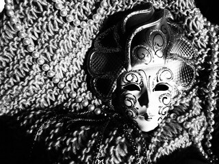 Carnival mask on a knitted background with beads and sparkles. Carnival festival costume element....
