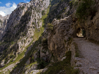 Tunnel pathway in Cares River canyon in Asturias. The Cares Route, placed in the very heart of Picos de Europa National Park, also known as “La Garganta Divina” (The Divine Gorge).