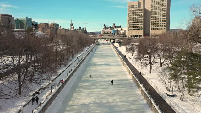Aerial view of Ottawa's downtown skyline and the Rideau Canal with people ice skating on it