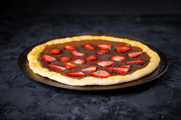 Pizza deliciosa com ingredientes na mesa de madeira com fundo escuro.