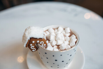 The mug with the christmas decorations and cookie on edge