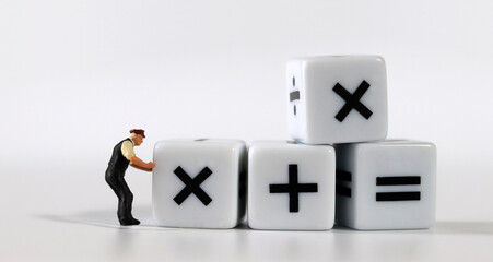 white dice with mathematical math symbols and miniature man
