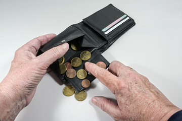 Elderly hands counting the few euro coins in a wallet, money concept for old age poverty and...