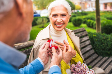 Obraz premium Beautiful senior couple bonding outdoors, marriage proposal