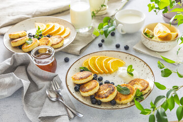 Delicious breakfast with curd fritter,  ricotta fritter or cottage cheese pancakes on ceramic plate. Gourmet healthy delicious morning breakfast. Morning sunny time
