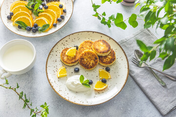 Delicious breakfast with curd fritter,  ricotta fritter or cottage cheese pancakes on ceramic plate. Gourmet healthy delicious morning breakfast. Morning sunny time