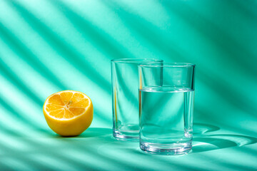 A glass of water and half a lemon. Sunlight. Light from the window.