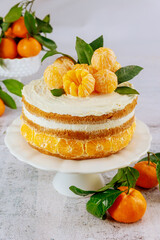 Tasty festive cake with peeled mandarins.