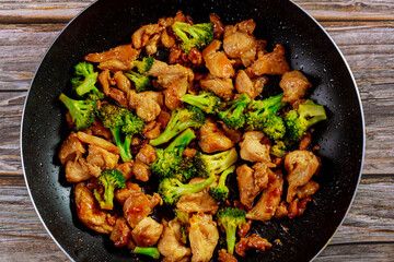 Stir fry with chicken and broccoli on wok. Chinese food.