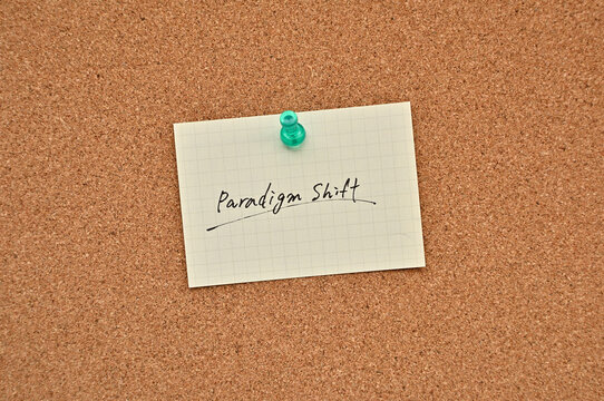 A piece of paper labeled paradigm shift is pinned to the corkboard.
