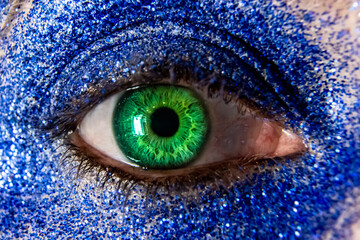 Close up detailed shot of bright green womans eye and eyebrow with focusing on the centre eye...