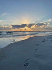 footprints in the sand with sunset skies on Florida Emerald Coast beach