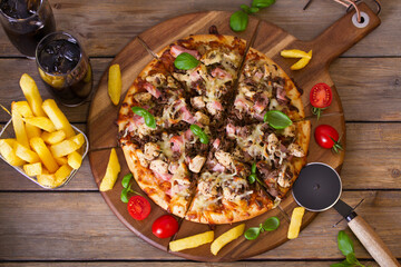 Spicy beef chicken and ham pizza with fries and two drinks. View from above, top view