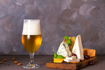 Beer and cheese. Glass of beer with cheese and walnuts. Ale and food concept. Copy space