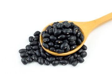 Healthy whole grains of black beans On a wooden spoon has a white background.