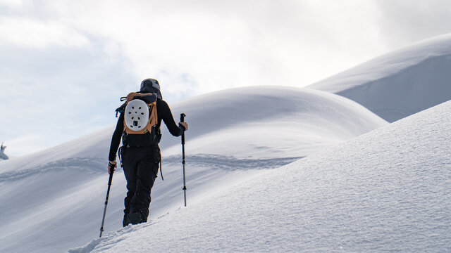 female skier climbing a mountain 