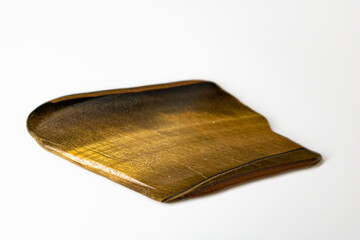 Polished slab of Tiger's Eye on neutral white background.