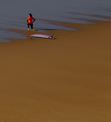 Young surfer girl exercise in the low tide beach sand, Odeceixe, Alentejo, Portugal. 