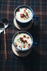 Cauliflower soup with crispy chorizo and parmesan shavings on a tartan woolen cloth.