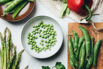 Overhead shot of display of spring vegetables  straight out of a bag on a kitchen table.