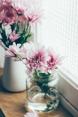 Pastel pink flowers on a vintage window sill.