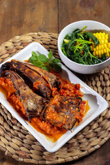 Sambal santan ikan panggang or ikan pari asap is smoke Stingray fish preserved by fumigation sauce, served with spicy coconut milk sauce and spinach soup.