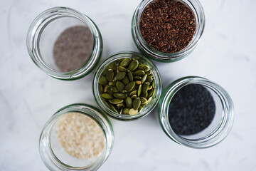 seed jars with sesame poppy pupmkin chia and flax seeds as important nutrient sources for nutrition shot on white background