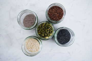 seed jars with sesame poppy pupmkin chia and flax seeds as important nutrient sources for nutrition shot on white background