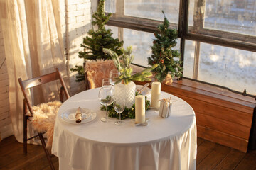 A festive day, a set table with New Year's decor. Candles and a cozy atmosphere. Christmas time. 
