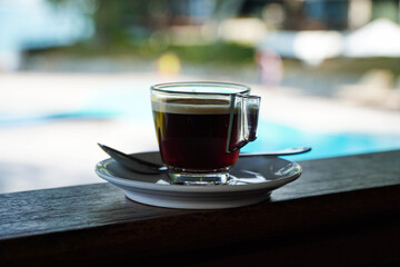 Cup of black hot coffee Seaside background, clear glass and saucer, Americano,Morning coffee background. Food and drink.