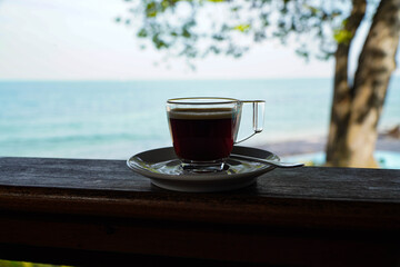 Cup of black hot coffee Seaside background, clear glass and saucer, Americano,Morning coffee background. Food and drink.