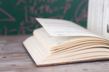 Books opened in front of the blackboard