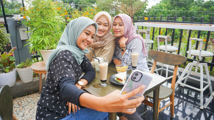 Asian hijab woman group selfie in cafe with friend