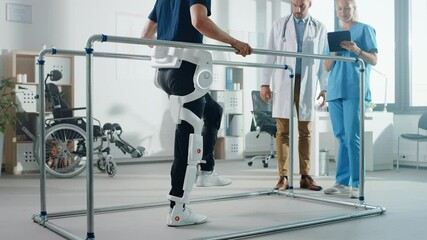 Modern Hospital Physical Therapy: Patient with Injury Walks Wearing Advanced Robotic Exoskeleton