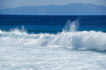 荒波の向こうに見える伊豆大島
