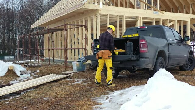 Construction Worker in His 40s and His Commercial Pickup Truck in Front of Newly Built Wooden House Structure