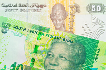 Fototapeta na wymiar A macro image of a shiny, green 10 rand bill from South Africa paired up with a green and yellow fifty piastre note from Egypt. Shot close up in macro.